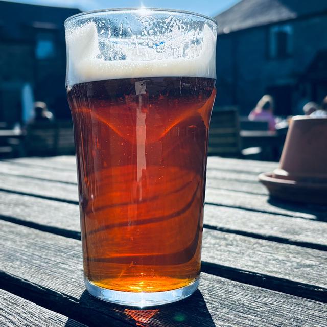 A pint of Jamaica Inn Ale on a table at the Jamaica Inn, Cornwall, partly drunk after tasting.