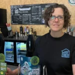 Sarah Saleh, owner of The Hop Shed Brewery, standing behind the brewery tap room bar in Worcestershire.