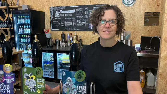 Sarah Saleh, owner of The Hop Shed Brewery, standing behind the brewery tap room bar in Worcestershire.