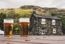 The Lake District Pub Scene: Ancient Inns, Fell Walkers, Local Ales and Villages Built Around the Bar Lake District pubs with pints of beer outside a traditional stone inn in the mountains